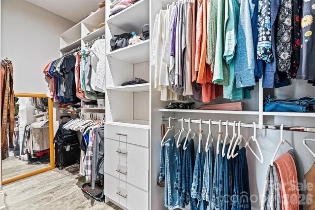 a view of walk in closet with clothes and shoes