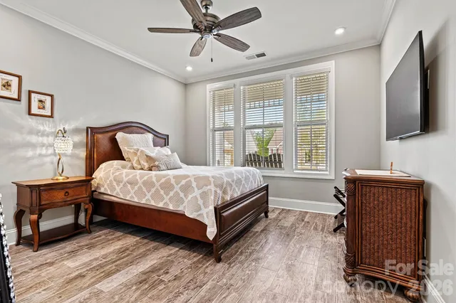 a bedroom with a large bed a flat tv screen and a dresser