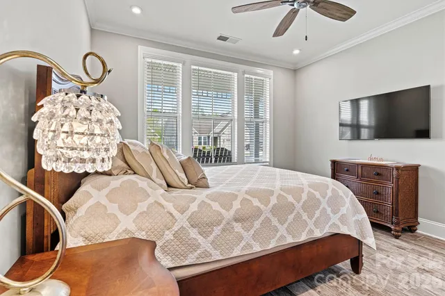 a bedroom with a bed and a flat tv screen on dresser