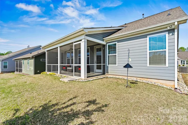 a view of a house with a large window and plants