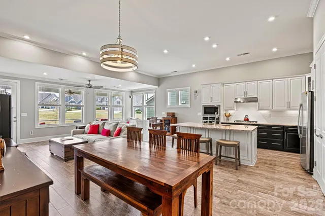 a large dining hall with stainless steel appliances granite countertop a stove dining table and chairs