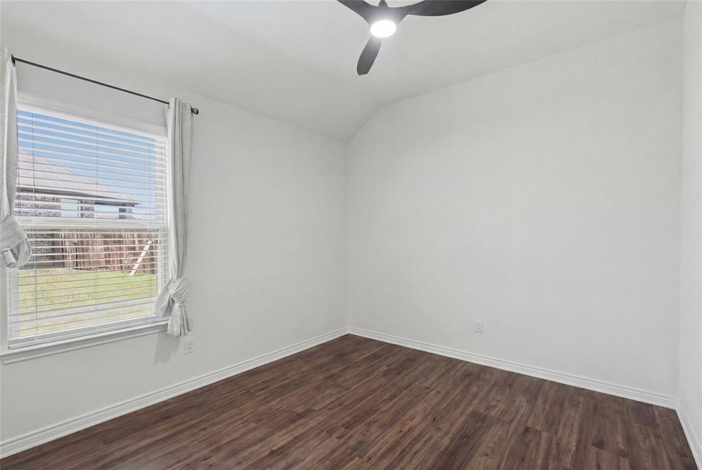 10101 Travis Road Little Elm, TX 75068 - Photo 24 of 26 a view of an empty room with wooden floor and a window