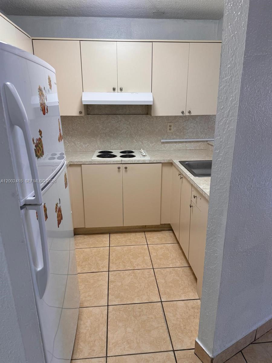 180 Royal Palm Road, Unit 216 Hialeah Gardens, FL 33016 - Photo 11 of 20 a kitchen with a sink a stove and cabinets