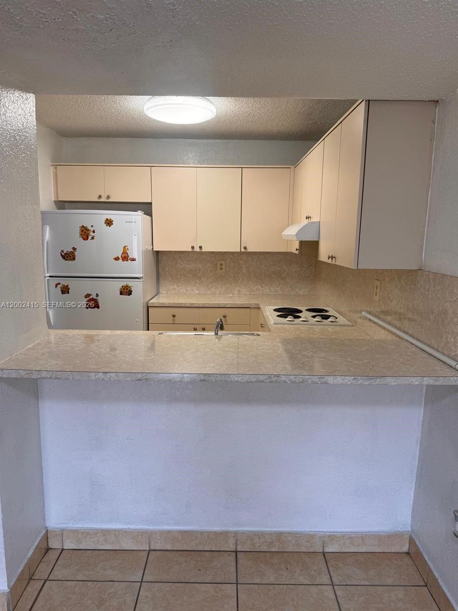 180 Royal Palm Road, Unit 216 Hialeah Gardens, FL 33016 - Photo 10 of 20 a kitchen with cabinets and white appliances
