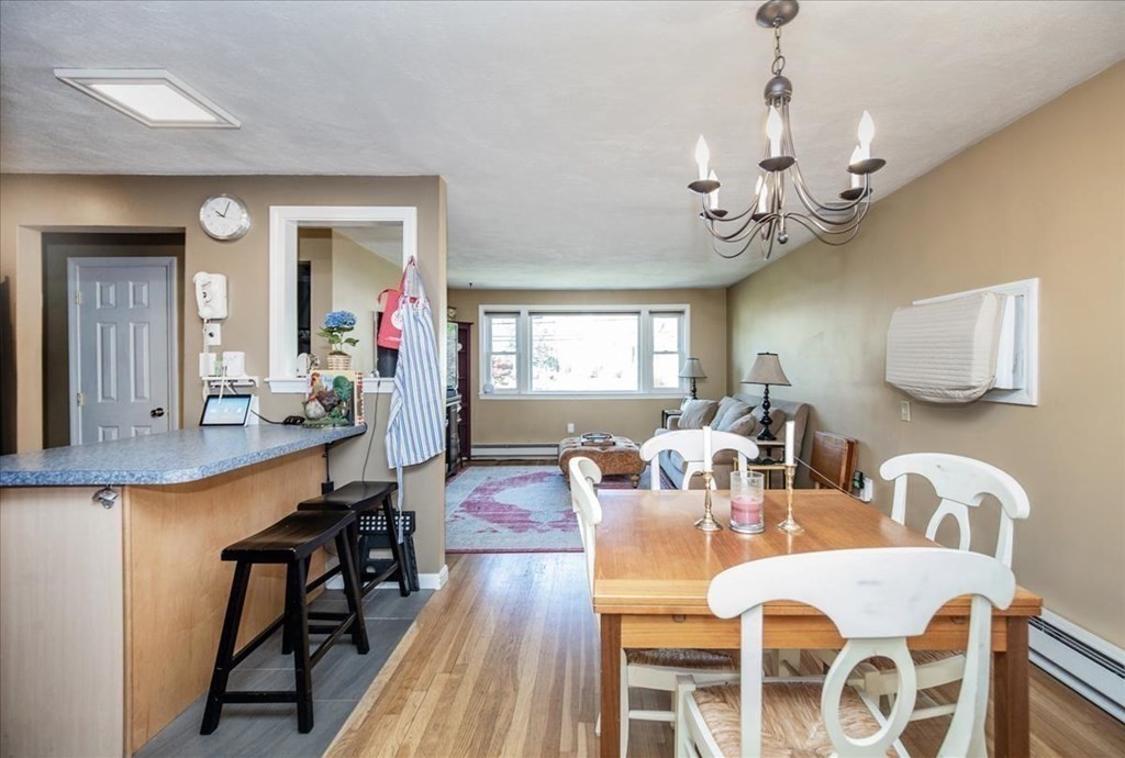 142 Spring Street Stoneham, MA 02180 - Photo 13 of 27 a view of a dining room with furniture a chandelier and wooden floor