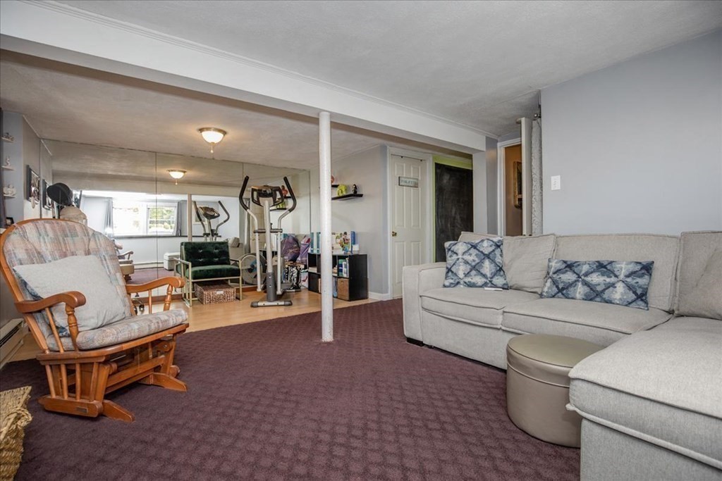 142 Spring Street Stoneham, MA 02180 - Photo 22 of 27 a living room with furniture and a wooden floor
