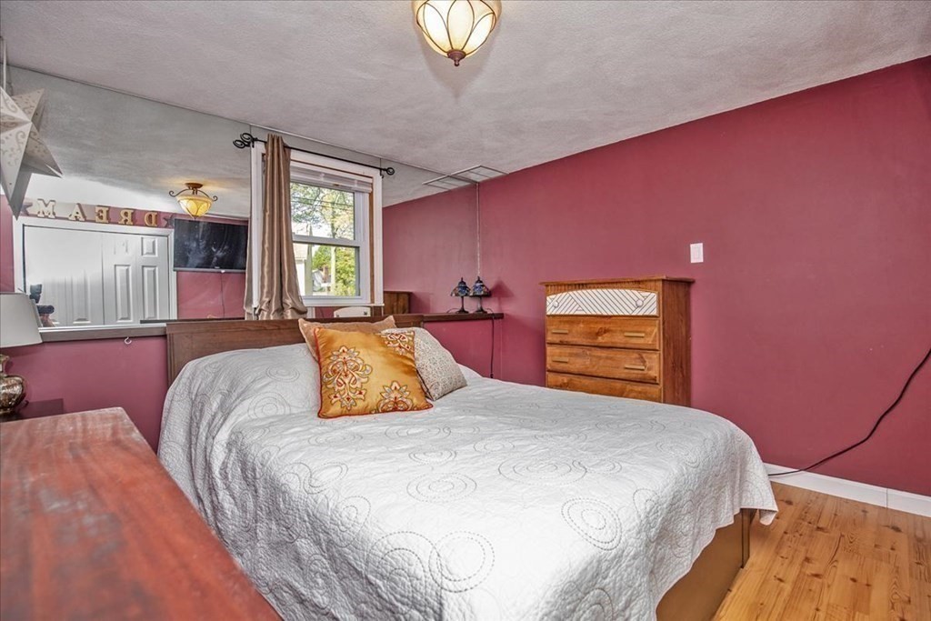 142 Spring Street Stoneham, MA 02180 - Photo 23 of 27 a bedroom with a bed and a chandelier