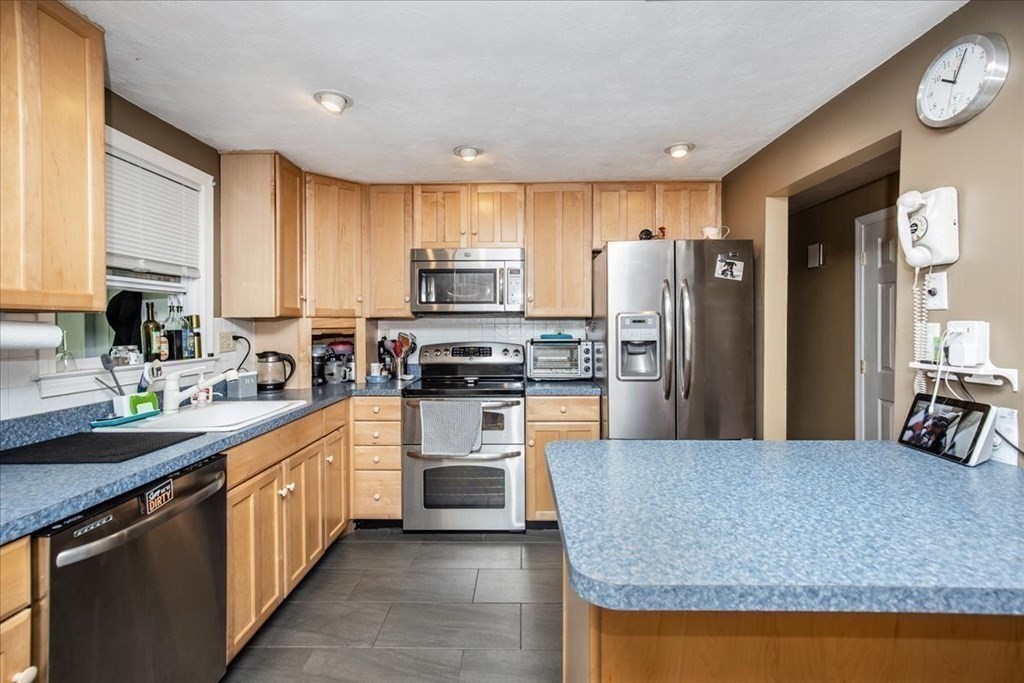 142 Spring Street Stoneham, MA 02180 - Photo 9 of 27 a kitchen with stainless steel appliances granite countertop a stove a sink a refrigerator and a microwave