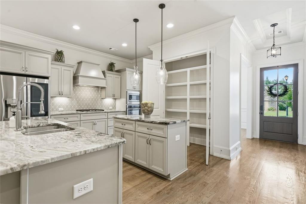 337 Rosshandler Road Suwanee, GA 30024 - Photo 9 of 45 a kitchen with stainless steel appliances granite countertop a sink a stove and a wooden floor