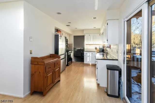 a kitchen with stainless steel appliances granite countertop a refrigerator a stove and a wooden floors