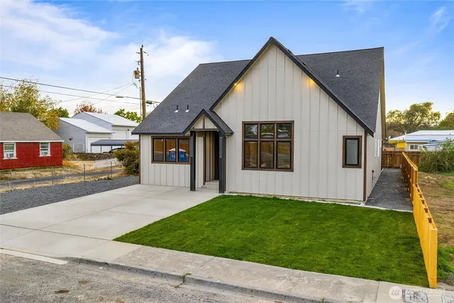 a front view of a house with a garden and yard