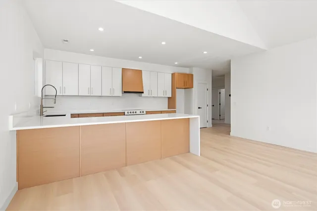 a large kitchen with stainless steel appliances granite countertop a sink and cabinets