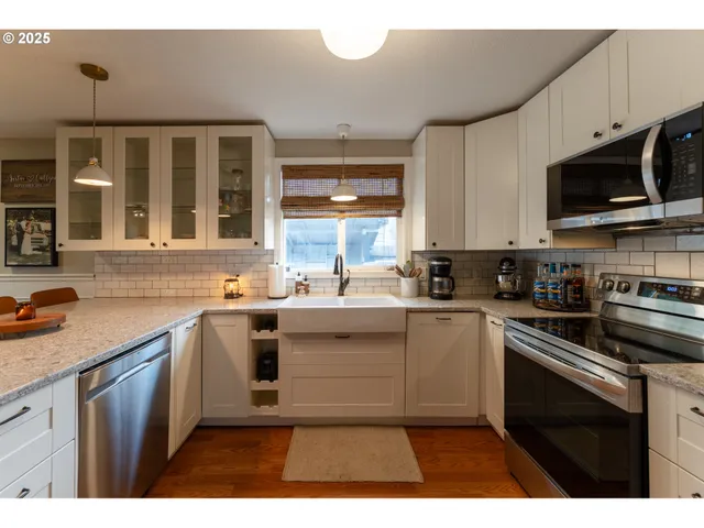 a kitchen with stainless steel appliances granite countertop a sink a stove top oven a counter space and cabinets