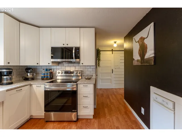 a kitchen with stainless steel appliances granite countertop a stove a sink and a microwave