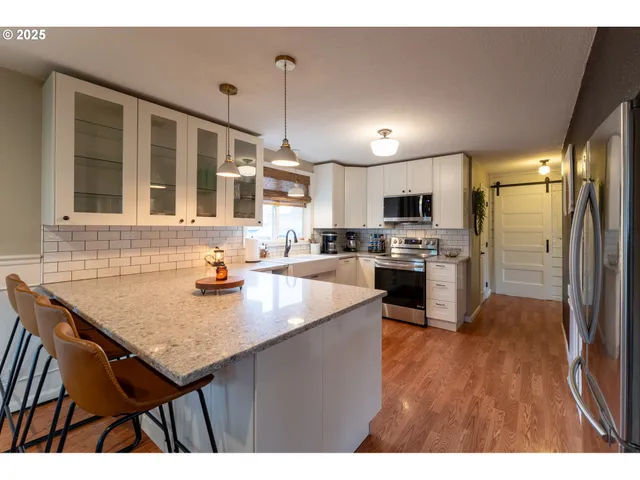 a kitchen with a sink a counter top stainless steel appliances and cabinets