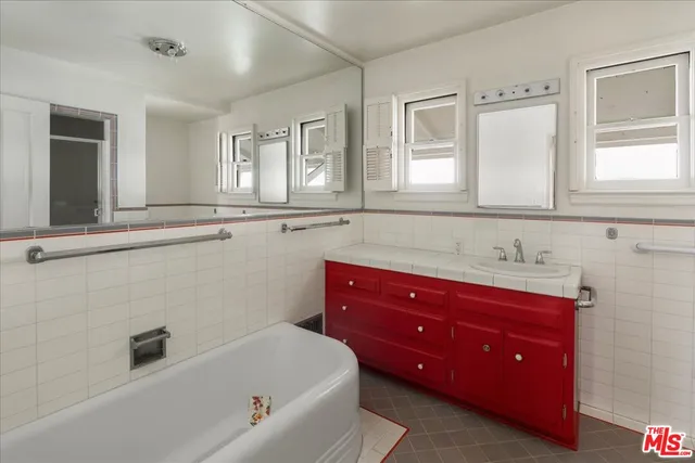 a bathroom with a tub sink and mirror