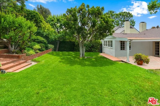 a view of a house with backyard and a tree