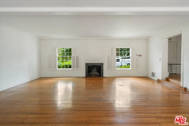 a view of an empty room with window and fire place