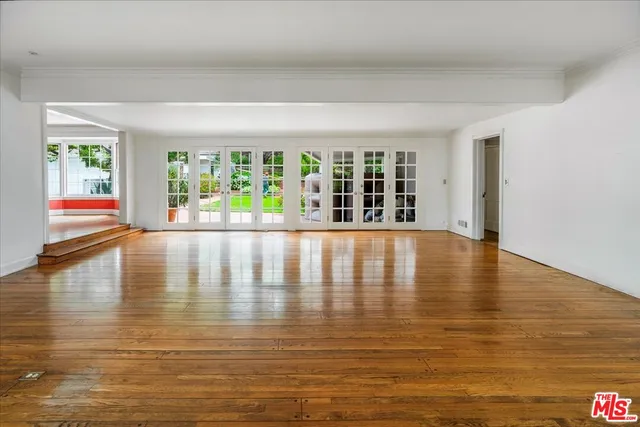 a view of empty room with wooden floor and floor to ceiling window