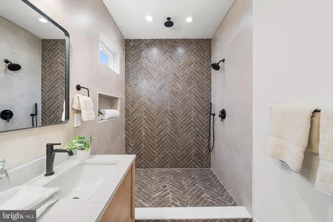 a bathroom with a granite countertop sink a mirror and shower