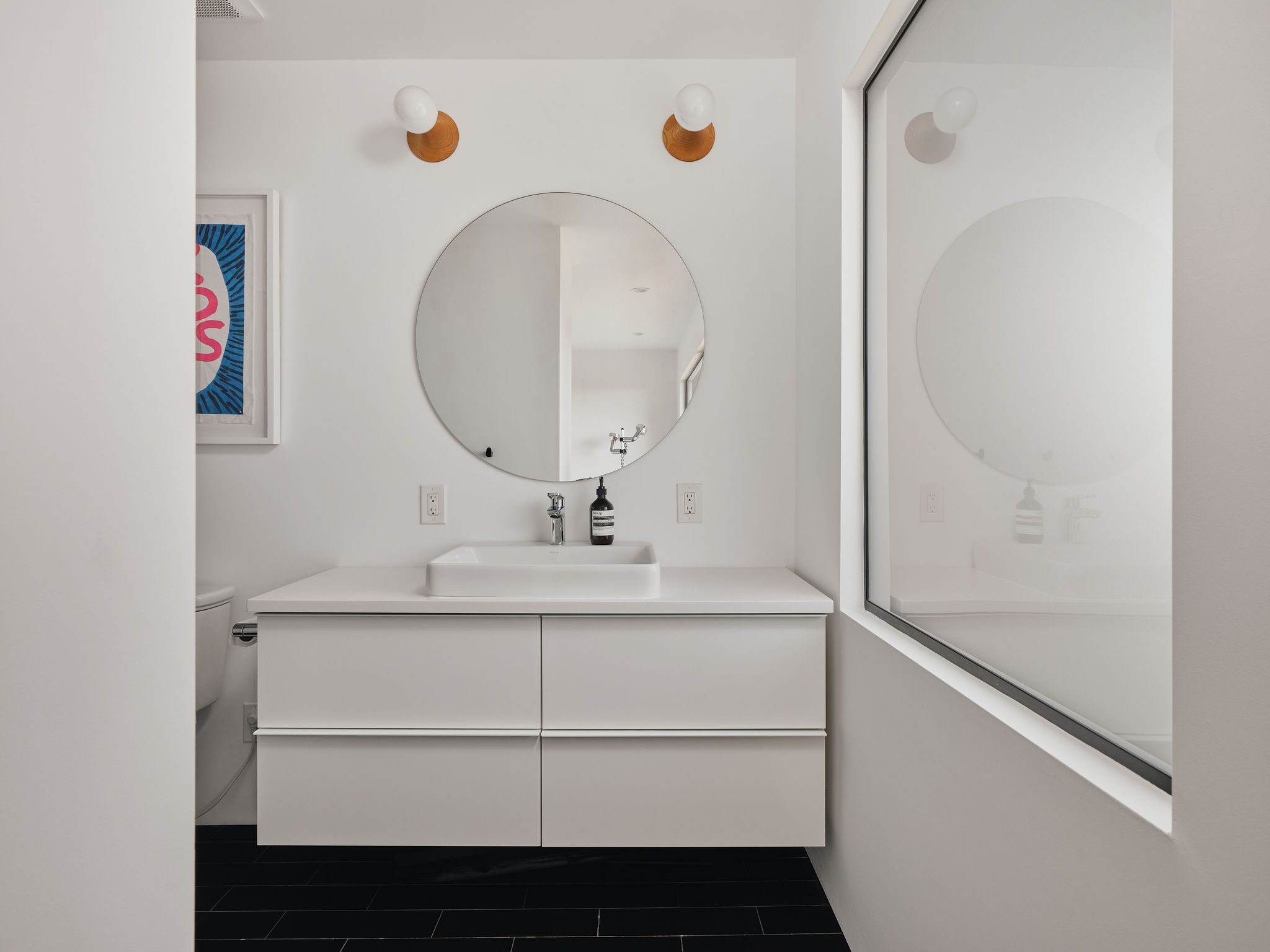 Undisclosed Address Austin, TX 78731 - Photo 22 of 26 A chic, minimalist en-suite bathroom features a floating vanity and sleek dark flooring.