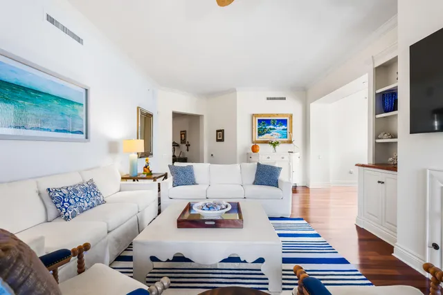 a dining room with wooden floor a chandelier a glass table and chairs