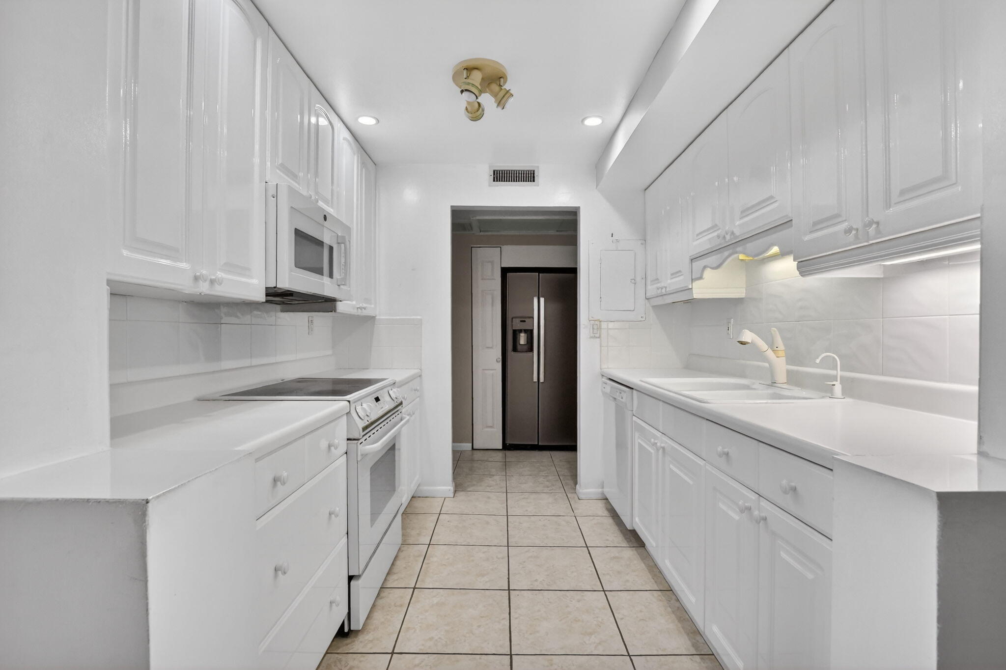 250 Northeast 20th Street, Unit 5220 Boca Raton, FL 33431 - Photo 6 of 40 a large white kitchen with granite countertop a sink