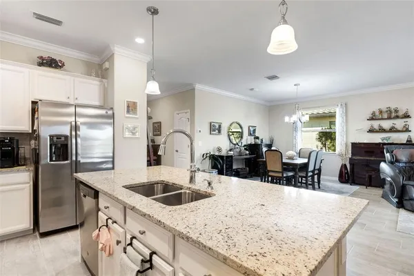 a kitchen with stainless steel appliances kitchen island granite countertop a sink a stove and a refrigerator