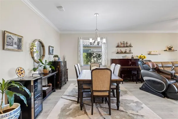 a view of a dining room with furniture a chandelier and wooden floor