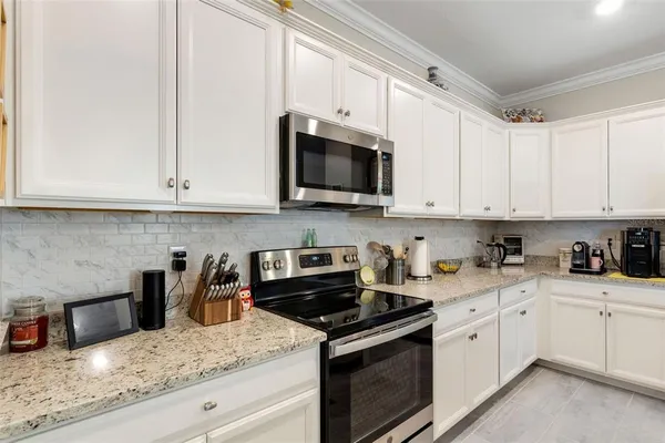 a kitchen with stainless steel appliances granite countertop white cabinets sink and dishwasher
