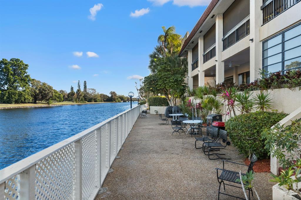 3511 Inverrary Drive, Unit 208 Lauderhill, FL 33319 - Photo 17 of 23 a view of a lake with a bench in front of house