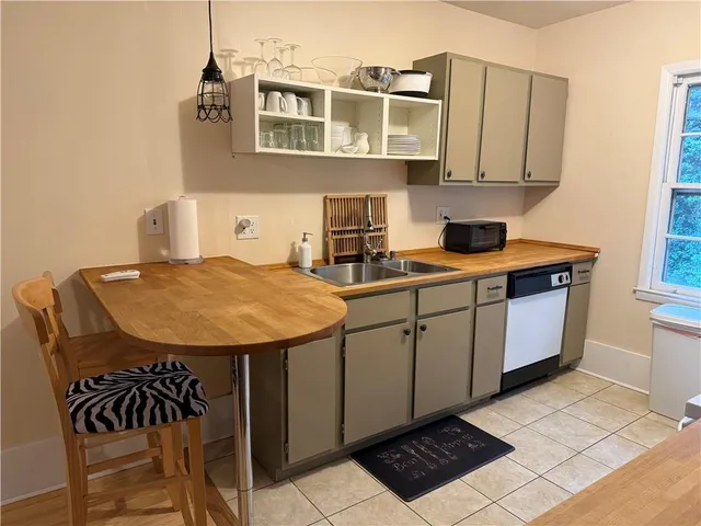 a view of a kitchen with kitchen island a sink a counter space and appliances