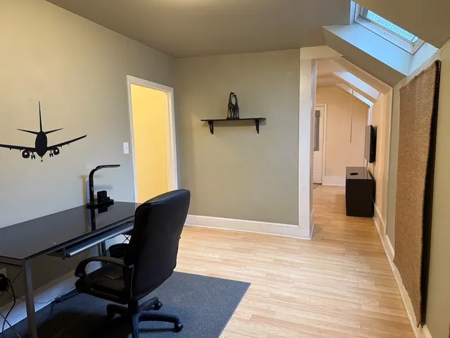 a view of a workspace room with wooden floor windows