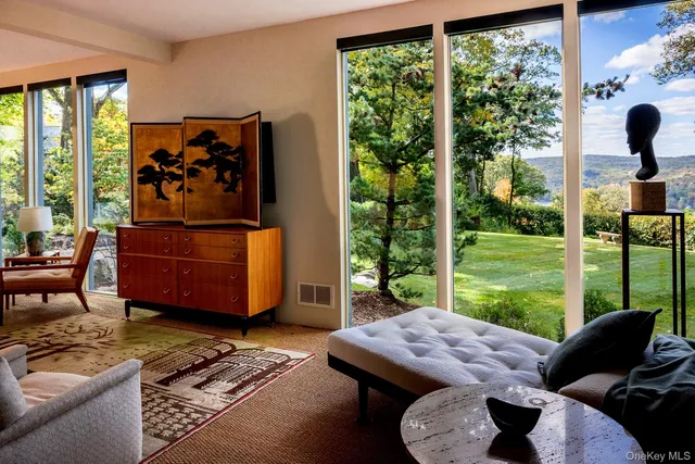 a living room with furniture and a floor to ceiling window