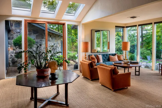 a living room with patio furniture and a potted plant