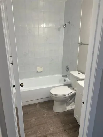 a view of an empty room with wooden floor