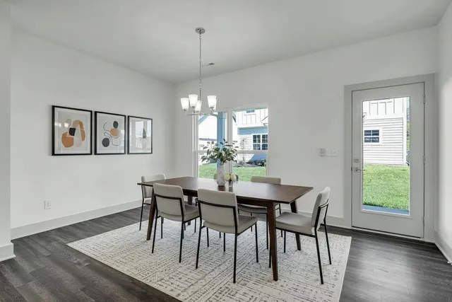 an empty room with wooden floor chandelier and windows