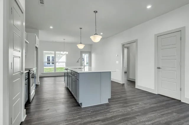 a view of kitchen with kitchen island stainless steel appliances sink and living room view