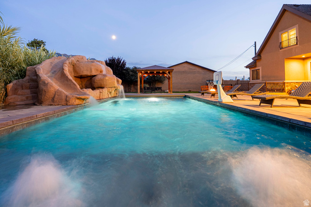 687 South 2080th Street East Springville, UT 84663 - Photo 142 of 149 Swimming pool with rock waterfall feature, integrated slide, and surrounding paver patio