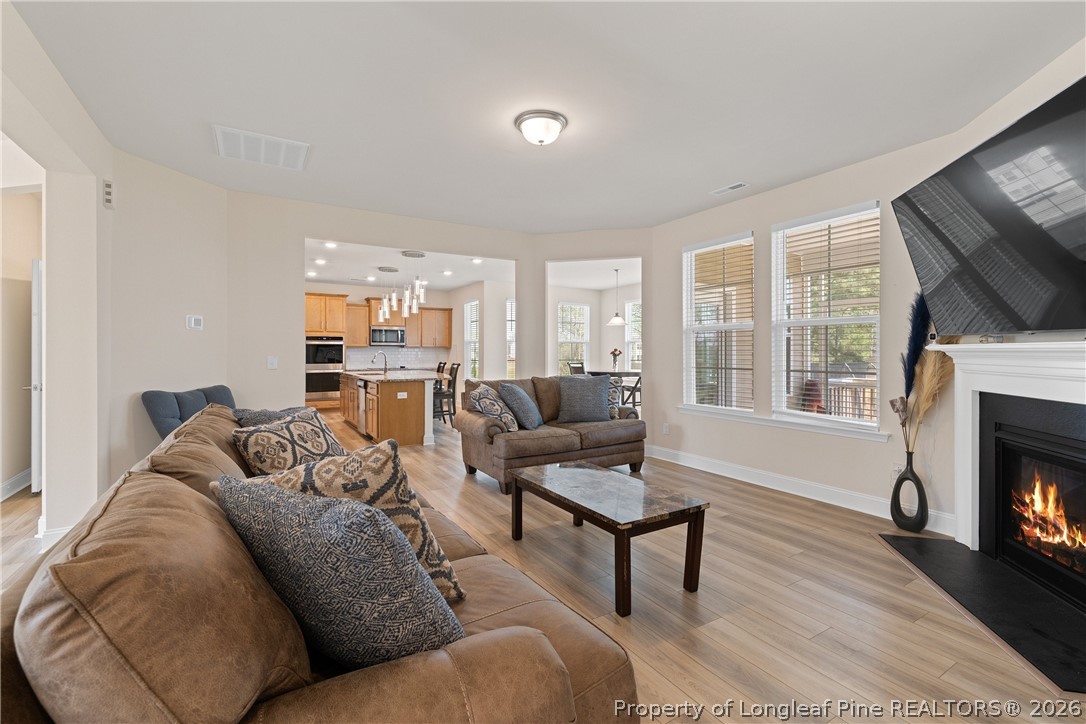 18 Two Belles Court Angier, NC 27501 - Photo 13 of 39 a living room with furniture a fireplace and a flat screen tv