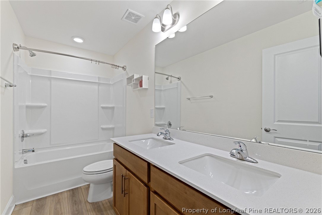 18 Two Belles Court Angier, NC 27501 - Photo 20 of 39 a bathroom with a sink a toilet a mirror and shower