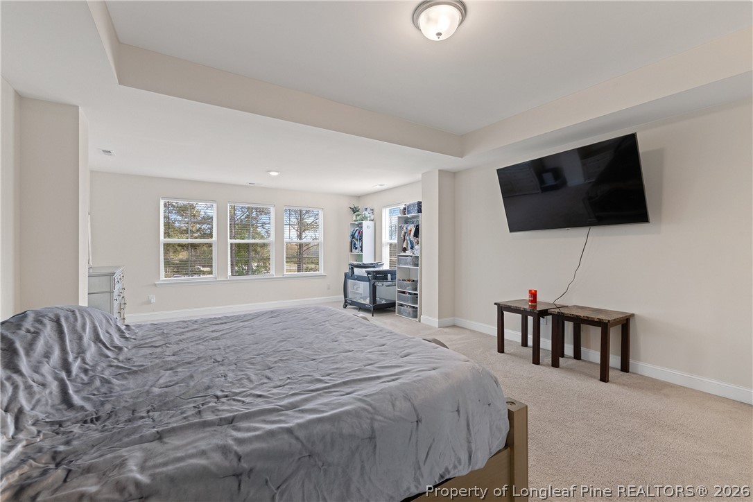 18 Two Belles Court Angier, NC 27501 - Photo 28 of 39 a bedroom with a bed a flat screen tv and a chandelier