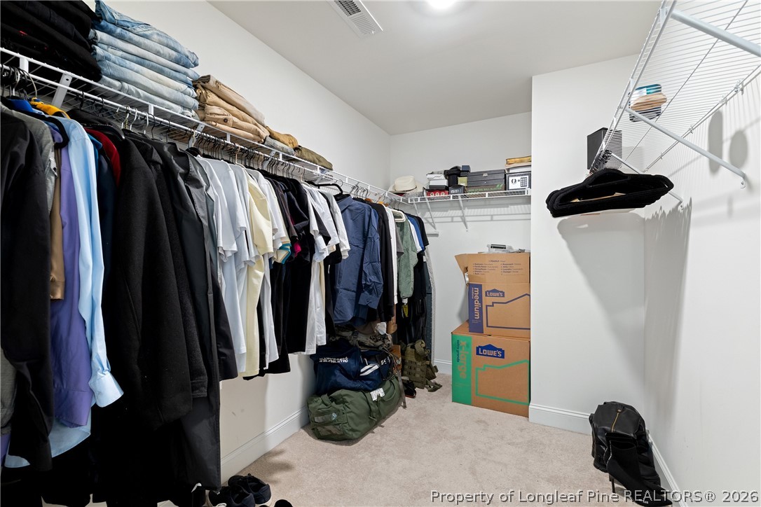 18 Two Belles Court Angier, NC 27501 - Photo 32 of 39 a view of walk in closet with clothes and shoes