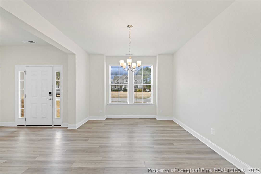 18 Two Belles Court Angier, NC 27501 - Photo 5 of 39 a view of an empty room with wooden floor and a window