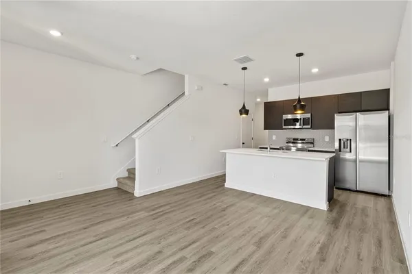 a kitchen with stainless steel appliances a refrigerator sink and microwave