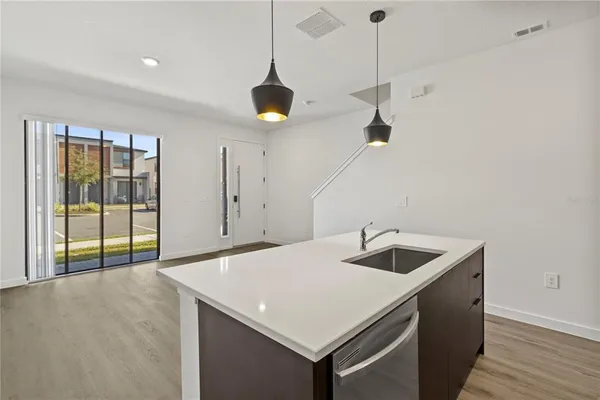 a kitchen with a sink a counter space and wooden floor