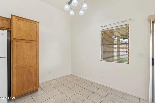 a view of an empty room with window chandelier fan