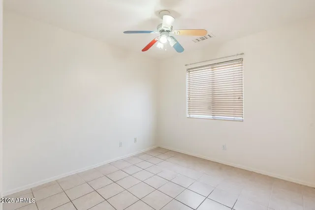 an empty room with windows and fan
