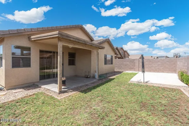 a view of a backyard with brick wall potted plants and a fire pit