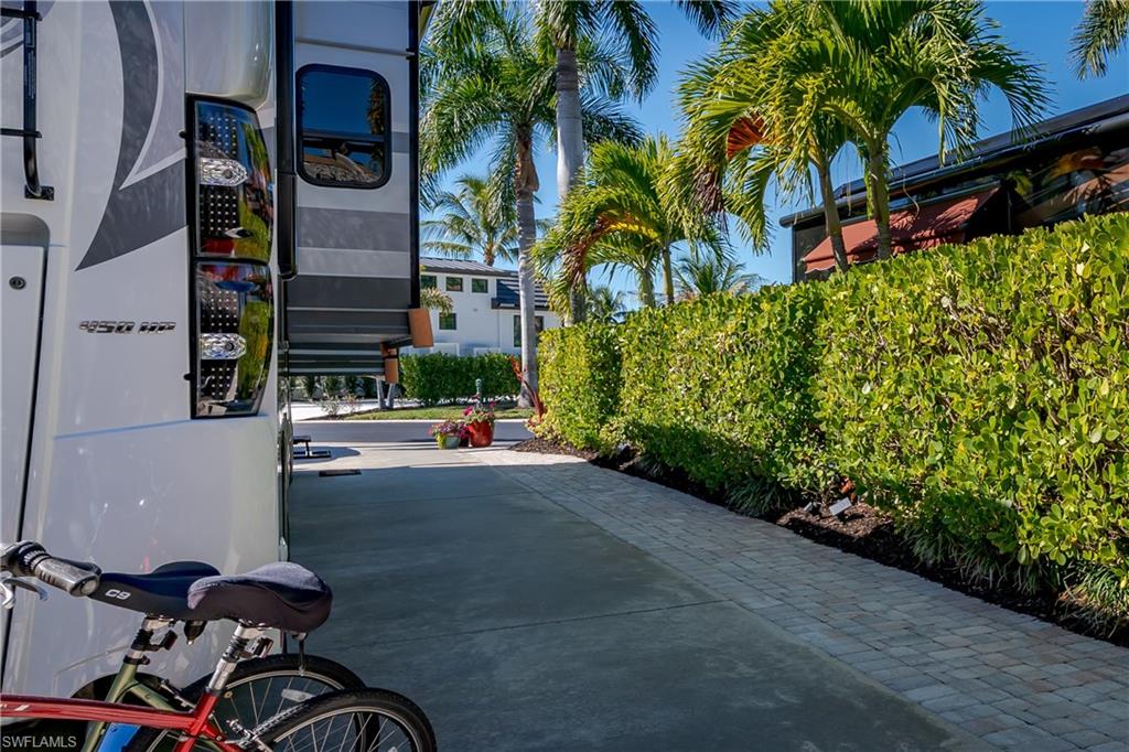 13466 Ladyfish Lane Naples, FL 34114 - Photo 26 of 40 a view of a street with potted plants and palm trees